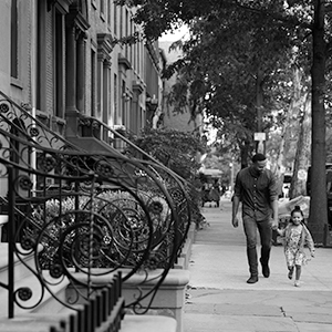 Man walking with child down city street