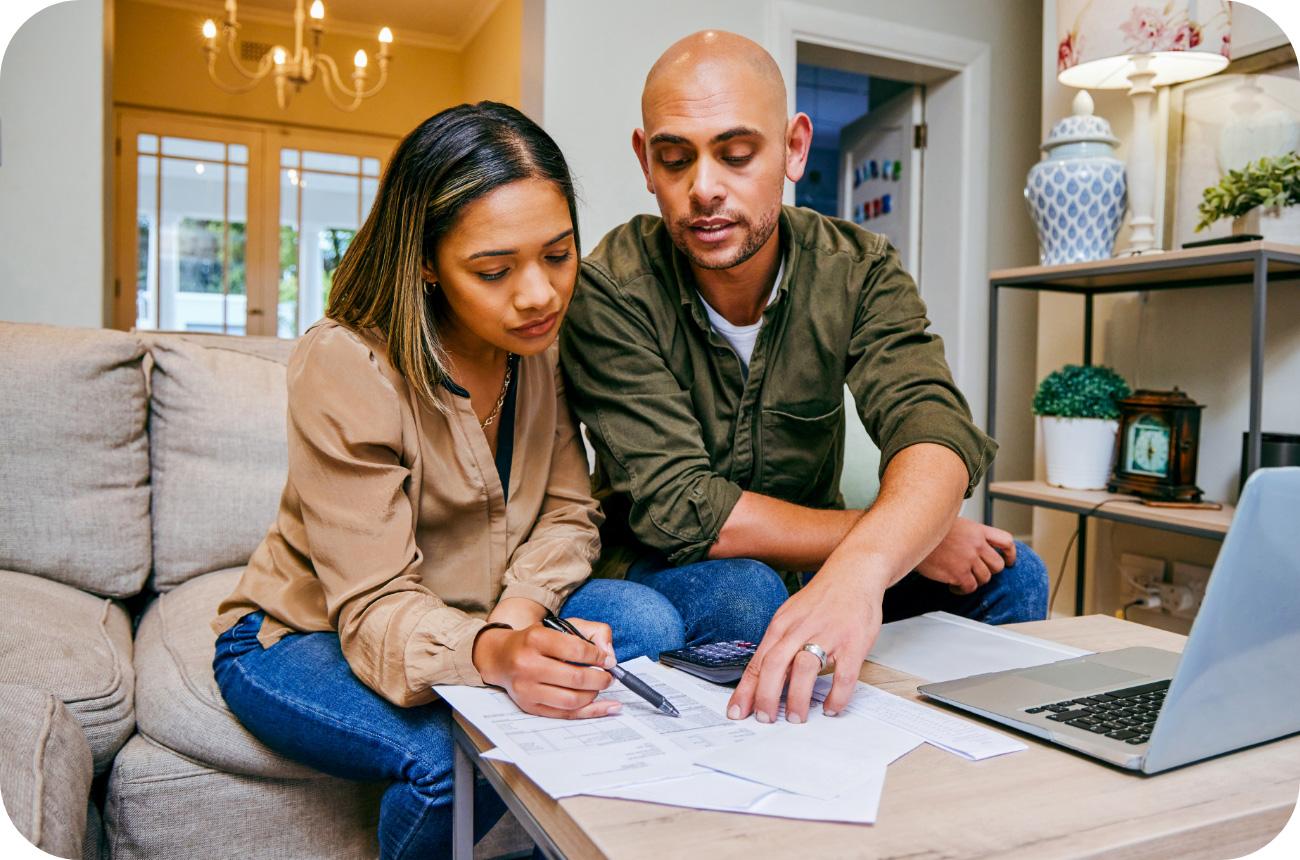 Latino couple sitting on couch reviewing documents